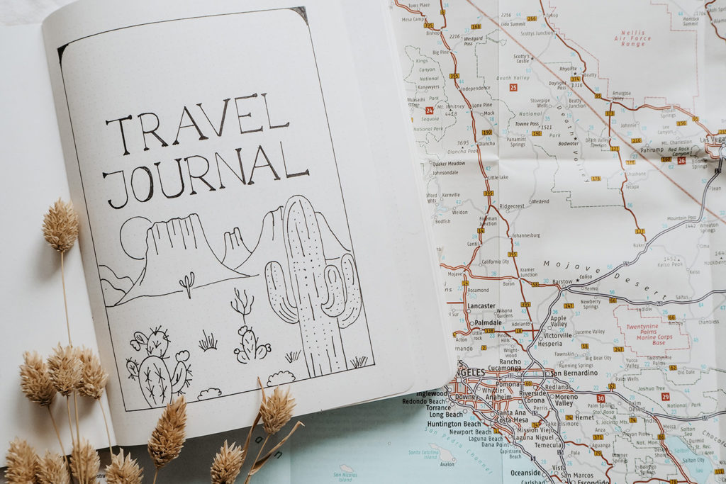 Reisetagebuch Schreiben Travel Journal liegt aufgeschlagen auf einer Landkarte der USA